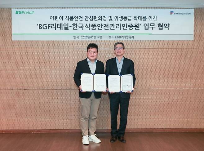 진영호 BGF리테일 상품해외사업부문장(왼쪽)과 홍진환 해썹인증원 홍진환 이사가 14일 서울 강남구 BGF리테일 사옥 7층 대회의실에서 진행된 어린이 식품안전 환경 조성을 위한 업무협약식 후 기념촬영을 하고 있다. BGF리테일 제공