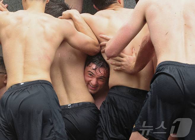 미국 해군사관학교에서 사관생도들이 14일(현지시간) 미국 메릴랜드 주 아나폴리스 미 해군 사관학교에서 '딕시 컵'을 떨어뜨리기 위해 인간 피라미드를 만들어 헌던 기념물 꼭대기에 오르고 있다. ⓒ 로이터=뉴스1