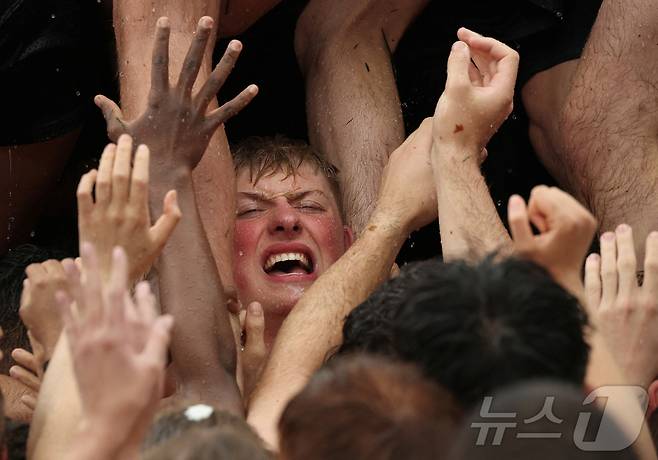 미국 해군사관학교에서 사관생도들이 14일(현지시간) 미국 메릴랜드 주 아나폴리스 미 해군 사관학교에서 '딕시 컵'을 떨어뜨리기 위해 인간 피라미드를 만들어 헌던 기념물 꼭대기에 오르고 있다. ⓒ 로이터=뉴스1