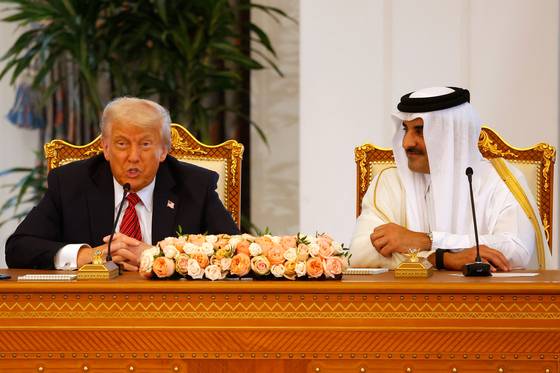 셰이크 타밈 빈 하마드 알사니 카타르 국왕 국왕(오른쪽)이 미소를 지으며 14일(현지시간) 14일 도하 왕궁에서 열린 서명식에서 도널드 트럼프 미국 대통령의 연설을 듣고 있다. AFP=연합뉴스