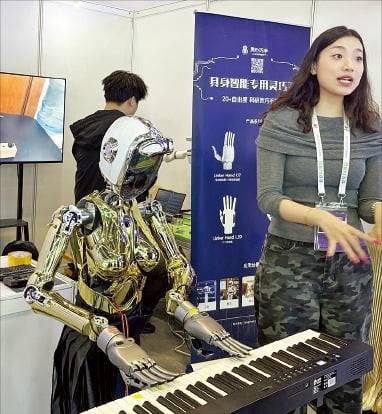 중국 베이징에서 열린 국제과학기술산업박람회에서 의료 기술 업체 중커상이건강과학기술의 경락 로봇이 마네킹을 상대로 마사지를 시연하고 있다(아래 사진). 로봇 회사 링신차오서우가 개발한 피아노 로봇이 피아노를 치고 있다. /베이징=김은정 특파원