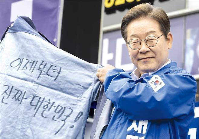 < 창원서 작업복 받은 이재명 > 이재명 더불어민주당 대선 후보가 14일 경남 창원 상남분수광장 유세에서 작업복을 들어 보이고 있다. 이날 부산에서 일정을 시작한 이 후보는 창원 통영 거제 하동 등 지역에서 유권자들을 만났다. /연합뉴스
