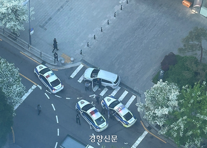 서울 마포경찰서 경찰관들이 지난 12일 오전 6시쯤 마포구 상암동 한 언론사 앞에서 시민을 차로 쳐 특수폭행 혐의를 받는 50대 남성 A씨를 현행범으로 체포하고 있다. 김모씨 제공