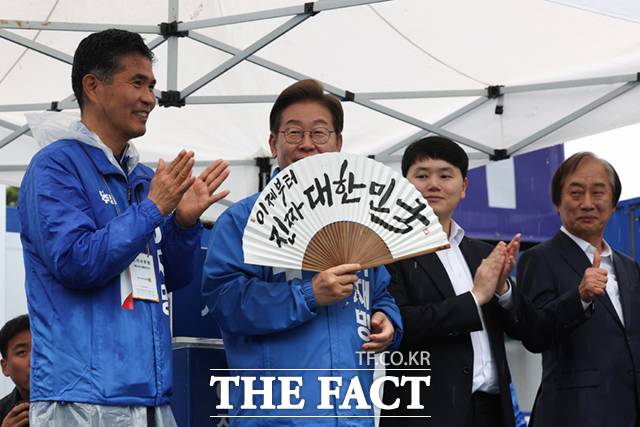 이재명 더불어민주당 대선후보가 16일 전북 전주시 전북대 후문에서 열린 유세에서 "이제부터 진짜 대한민국"이라고 적힌 부채(합죽선)을 선물받아 들어보이고 있다. /전주=뉴시스