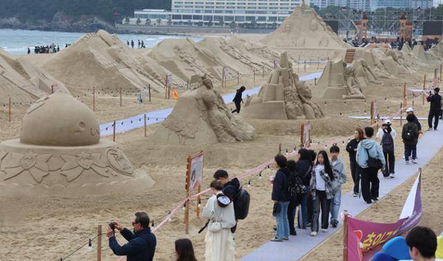 '2025년 해운대 모래축제' 개막을 하루 앞둔 15일 오후 부산 해운대해수욕장을 찾은 시민과 관광객들이 다양한 모래조각 작품을 구경하고 있다. 연합뉴스