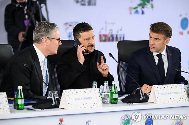 젤렌스키 대통령 (티라나 로이터=연합뉴스) 16일(현지시간) 알바니아 수도 티라나에서 열린 유럽정치공동체(EPC) 정상회의에 참석한 볼로디미르 젤렌스키 우크라이나 대통령(가운데)이 통화를 하고 있다. 왼쪽은 키어 스타머 영국 총리, 오른쪽은 에마뉘엘 마크롱 프랑스 대통령. 2025.05.16 photo@yna.co.kr