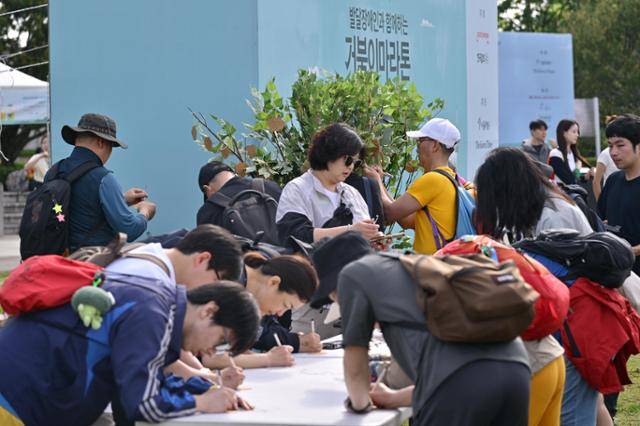 제491회 한국일보 거북이마라톤 '굿피플 발달장애인 인식개선을 위한 거북이마라톤'이 열리는 17일 오전 서울 중구 남산 백범광장에서 참가자들이 소망트리에 걸 희망 메시지를 적고 있다. 최주연 기자