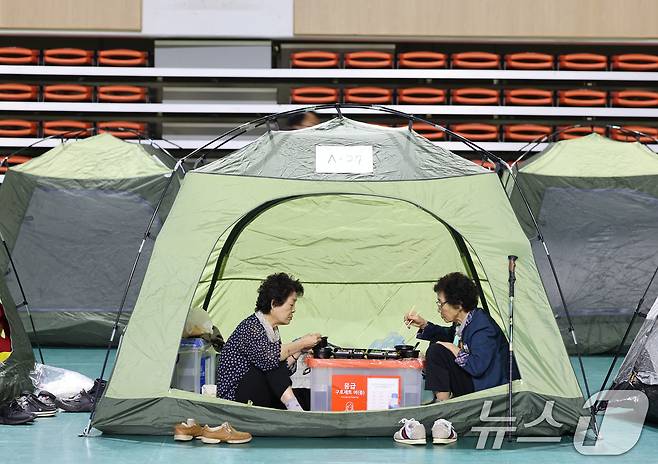 전날 발생한 금호타이어 광주공장 화재가 이튿날이 18일에도 이어지는 가운데 광주 남구 광주여대 체육관에 피해 주민을 위해 마련된 대피소에서 주민들이 쉬고 있다. 2025.5.18/뉴스1 ⓒ News1 박지현 기자