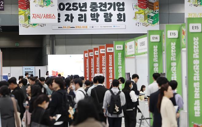 지난 23일 서울 강남구 코엑스에서 열린 2025년 중견기업 일자리 박람회에서 구직자들이 채용정보를 얻고 있다. 9회를 맞은 올해 중견기업 일자리 박람회는 유망 중견기업 110곳과 구직자 5천여명이 참가해 역대 최대 규모로 치러진다. /뉴스1
