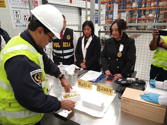 페루 당국이 페루 리마에서 불법 채굴로 추정되는 수출 회사로부터 아랍에미리트로 향하던 금괴 4개를 압수한 후 세관 직원이 금괴의 포장을 풀고 있다. /로이터=뉴스1