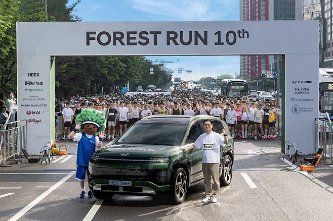 정유석 현대차 국내사업본부 부사장이 지난 17일 서울 여의도에서 열린 '포레스트런 2025'에서 아이오닉 9 앞에서 '포레스트런'의 새로운 마스코트 '그루'와 기념 촬영하고 있다. /현대차 제공
