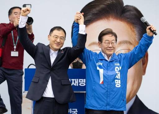 더불어민주당 이재명 대선후보가 16일 전북 익산시 익산역 동부광장에서 열린 유세에서 무소속 김상욱 의원과 손을 들어 인사하고 있다. (연합뉴스)