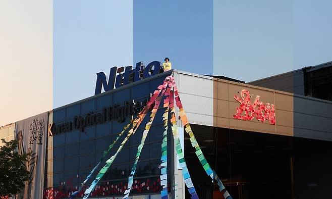 지난 12일 경북 구미시 한국옵티칼하이테크 공장에서 새벽 5시부터 저녁 8시까지 찍은 사진을 이어붙여 고공농성의 하루를 담았다.이런 하루가 498번 지났다. 오는 21일 고공농성 500일을 맞는다. 닛토(Nitto)는 고용을 승계하라!\\\'가 적힌 몸자보를 입은 박정혜씨가 카메라를 응시하고 있다. 백소아 기자 thanks@hani.co.kr