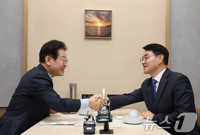 이재명 더불어민주당 대표와 박용진 전 의원이 21일 서울 여의도의 한 식당에서 만나 대화를 하던 중 악수하고 있다. (공동취재) 2025.2.21/뉴스1 ⓒ News1 안은나 기자