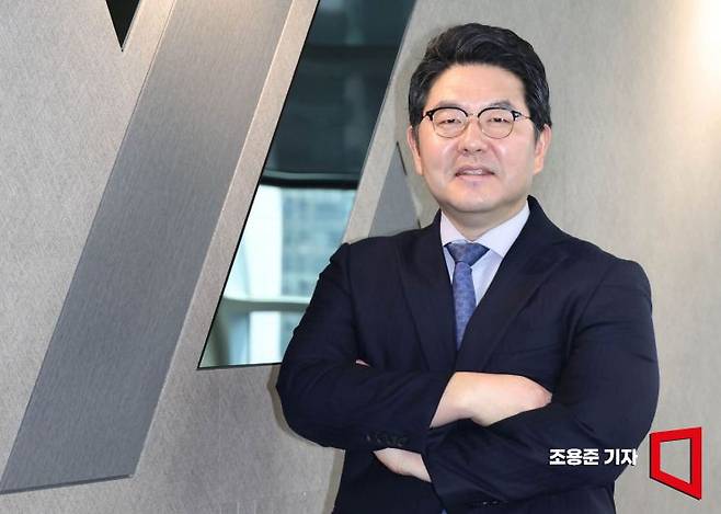 강경훈 법무법인 YK 대표변호사가 19일 서울 강남구 사무실 회사 로고 앞에서 포즈를 취하고 있는 모습. 조용준 기자