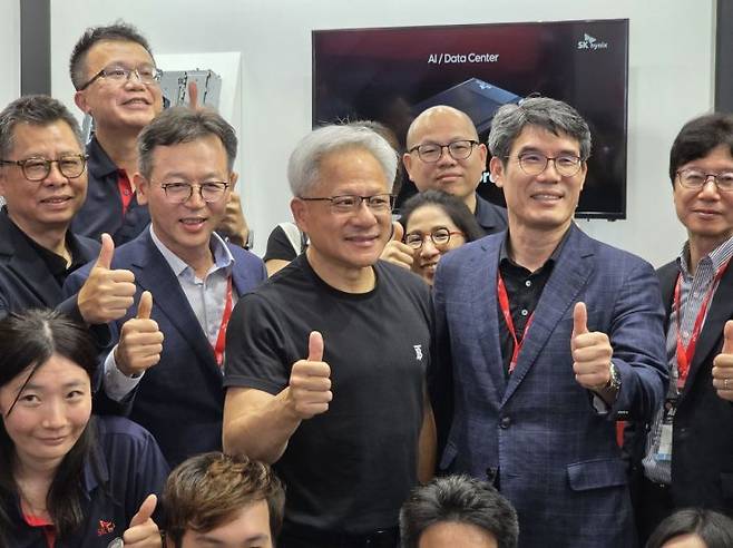 젠슨 황 엔비디아 최고경영자(CEO)가 20일 오후 대만 타이베이 난강 전시센터에서 열린 '컴퓨텍스 2025' 전시장에서 SK하이닉스 부스를 찾아 SK하이닉스 임직원과 기념촬영을 하고 있다. 공동취재단