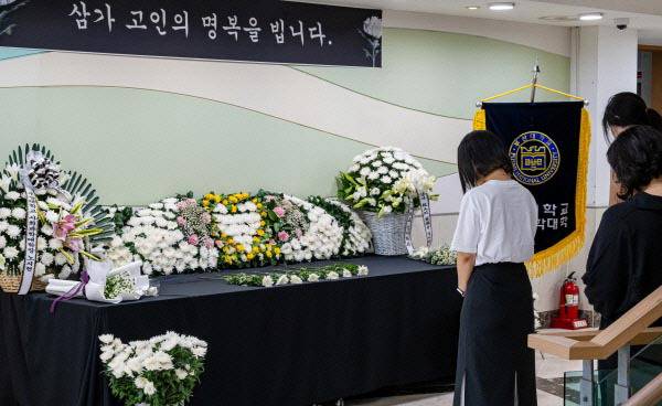 지난해 6월 부산대 인문관 앞에서 발생한 지게차 사고로 숨진 학생의 분향소에서 학부생들이 헌화하고 있다. 국제신문 DB