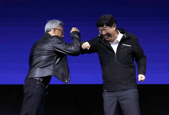 젠슨 황과 폭스콘 CEO 20일 대만 타이베이 난강전시관에서 2025 컴퓨텍스 기조 연설을 하던 류양웨이(오른쪽) 폭스콘 최고경영자(CEO)가 연설 무대로 젠슨 황 엔비디아 CEO를 '깜짝 호출'한 뒤 팔을 맞부딪치며 웃고 있다. /AP 연합뉴스