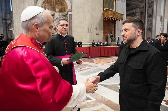 18일 교황 레오 14세(왼쪽)가 바티칸 성 베드로 대성당에서 교황 취임식 미사 후 볼로디미르 젤렌스키(오른쪽) 우크라이나 대통령과 인사를 나누고 있다. /EPA 연합뉴스