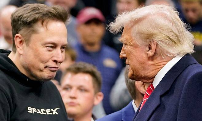 테슬라 최고경영자 일론 머스크가 지난 3월 22일(현지시각) 미국 펜실베이니아주 필라델피아에서 열린 전미대학체육협회(NCAA) 남자 레슬링 챔피언십 대회에 참석해 도널드 트럼프 미국 대통령과 인사하고 있다. 필라델피아/로이터 연합뉴스