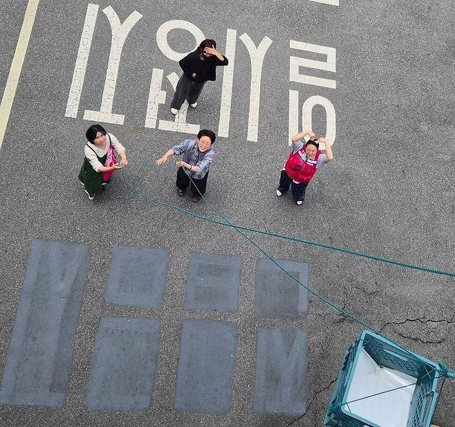 고공농성 500일을 열흘 앞둔 2025년 5월11일, 박정혜씨를 응원하러 온 시민들이 점심식사를 올려보낸 뒤 빈 도르래를 내리고 있다. 신다은 기자