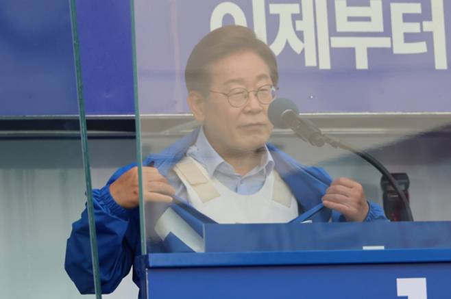 ▲ 더불어민주당 이재명 대선 후보가 지난 21일 자신의 지역구인 인천광역시 계양역 앞 유세에서 방탄유리, 방탄조끼 비판에 대해 항변하던 중 점퍼 속 방탄조끼를 보여주고 있다. /연합뉴스