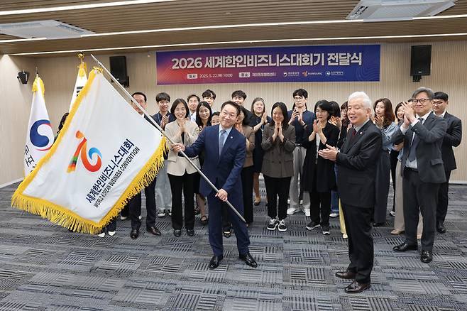 유정복 인천시장이 22일 재외동포웰컴센터에서 열린 '2026 세계한인비즈니스대회기 전달식'에서 이상덕 재외동포청장에게 대회기를 전달받은 뒤 흔들고 있다. 사진=인천시청