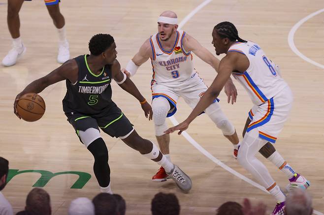 <yonhap photo-3320=""> Minnesota Timberwolves guard Anthony Edwards (5) is double-teamed by Oklahoma City Thunder guard Alex Caruso (9) and forward Jalen Williams (8) during the second half of Game 1 of an NBA basketball Western Conference Finals playoff series Tuesday, May 20, 2025, in Oklahoma City. (AP Photo/Nate Billings)/2025-05-21 12:35:41/ <저작권자 ⓒ 1980-2025 ㈜연합뉴스. 무단 전재 재배포 금지, AI 학습 및 활용 금지></yonhap>
