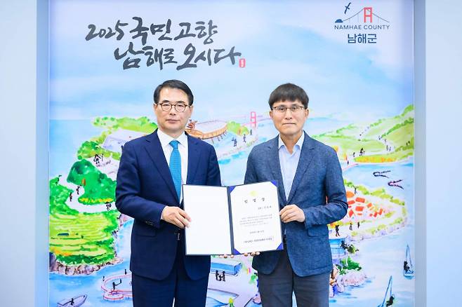 장충남 남해군수(왼쪽)가 김용태 신임 대표에게 임명장을 수여한 뒤 기념촬영을 하고 있다./사진=남해군