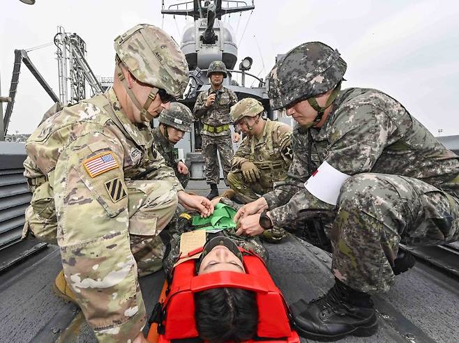 한미연합군사령부가 22일 진행한 연합·합동 의무지원훈련 중 한미 장병이 고속정에서 후송을 위해 척추부상을 입은 해병대 장병을 들것에 고정시키고 있다. 한미연합군사령부 제공