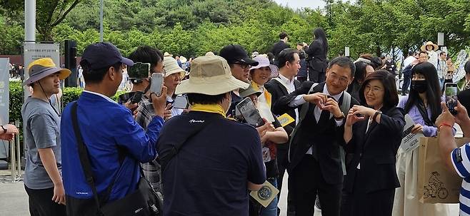 김상욱 국회의원이 노무현 전 대통령 묘역 앞에서 참배객들에게 둘러싸여 기념사진을 찍고 있다. 최상원 기자