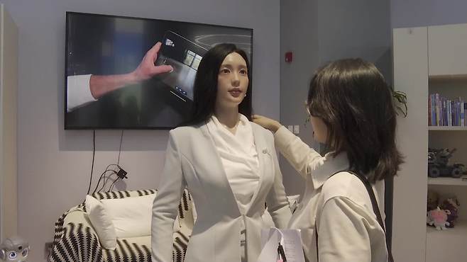 중국 베이징에 전시된 한 휴머노이드. 가정용이지만 성인용 로봇처럼 사람의 피부와 외형을 모사했다. 전시관에 방문한 많은 외신 매체 기자들이 옆에서 기념사진을 찍을 정도로 눈길을 끌었다.