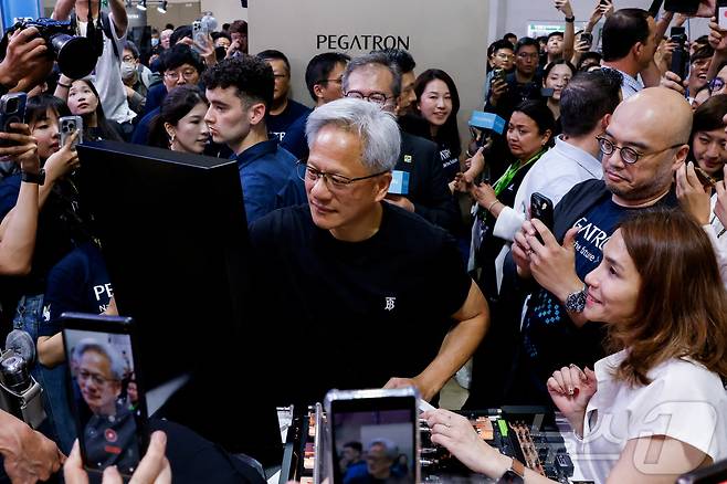 대만 타이베이에서 열린 컴퓨텍스를 방문한 엔비디아의 젠슨 황 CEO가 20일(현지시간) 페가트론 부스에서 자신의 이름에 서명하고 있다. 2025.5.21ⓒ 로이터=뉴스1 ⓒ News1 신기림 기자