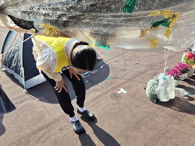 고공농성 500일을 열흘 앞둔 2025년 5월11일, 박정혜씨가 취재진을 안내하러 텐트 안으로 들어서고 있다. 천막이 낮아 늘 허리를 굽혀야 해, 허리 통증이 심하다. 신다은 기자