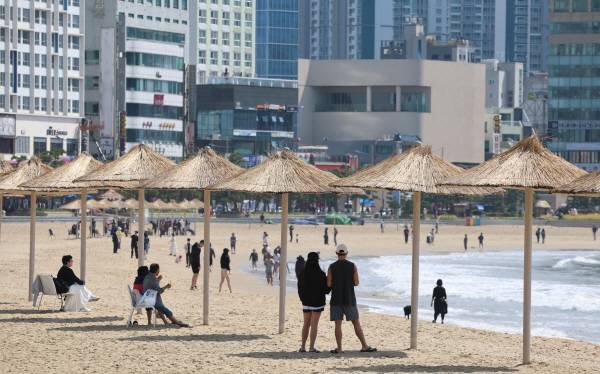 맑은 날씨를 보인 25일 부산 수영구 광안리해수욕장에서 관광객과 시민이 산책을 즐기고 있다. 연합뉴스