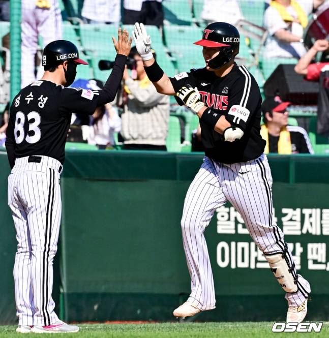 이주헌(오른쪽)이 홈런을 치고 정수성 코치와 하이파이브를 하고 있다.