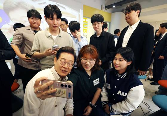 이재명 더불어민주당 대통령 후보가 26일 경기 수원시 아주대학교에서 대학생 간담회를 마친 뒤 참석 학생들과 셀카를 찍고 있다. 공동취재