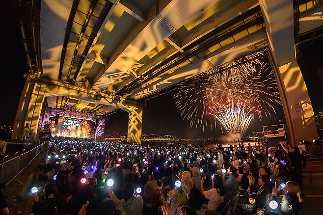 Fans cheer for Seventeen on Jamsu Bridge in Seoul, Sunday, as the group performs its 10th anniversary concert "B-Day Party: Burst Stage." (Pledis Entertainment)
