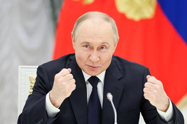 블라디미르 푸틴 러시아 대통령이 26일 러시아 크렘린궁에서 러시아 기업인들과의 회담에서 주먹을 쥐어 보이고 있다. 모스크바=타스 연합뉴스