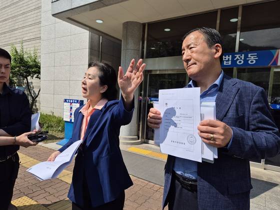 김영선 전 국회의원(왼쪽)이 26일 오전 경남 창원지법 법정동 앞에서 '홍준표 전 대구시장 측근이 미래한국연구소 쪽에 준 수표'라며 수표 2장을 공개하고 있다. 안대훈 기자