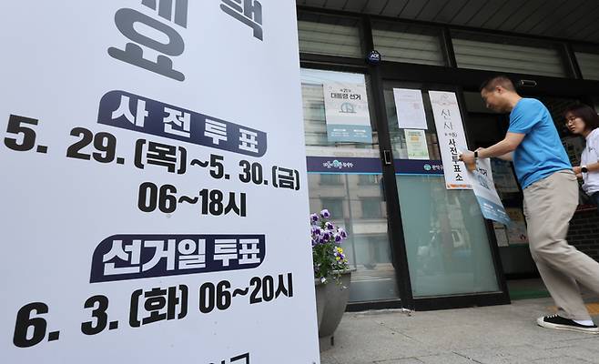 제21대 대통령선거 사전투표를 하루 앞둔 28일 서울 관악구 신사동 복합청사에서 관계자들이 사전투표소 안내문을 붙이고 있다. 연합뉴스