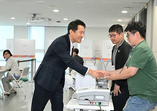오세훈 서울시장이 28일 오전 중구 신당누리센터 사전투표소를 찾아 투표소 운영을 준비 중인 직원들을 격려하고 있다. 서울시