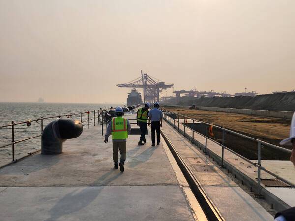 28일 인천항만공사 관계자들이 인천신항 1-2단계 하부 축조공사 현장을 둘러보고 있다. 뒷편으로 이미 운영 중인 인천신항 1-1단계 선광컨테이너터미널이 보인다. 이병기기자