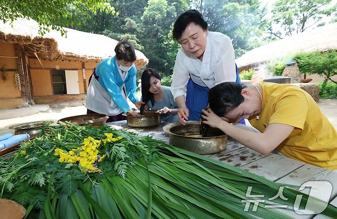 단오(음력 5월5일)를 이틀 앞둔 29일 경기 용인시 기흥구 한국민속촌에서 관광객들이 창포물에 머리 감기 체험을 하고 있다. 2025.5.29/뉴스1 ⓒ News1 김영운 기자