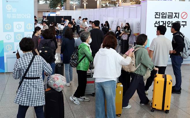 29일 오전 인천공항에서 여행객들이 출국 전 투표를 하려고 기다리고 있다