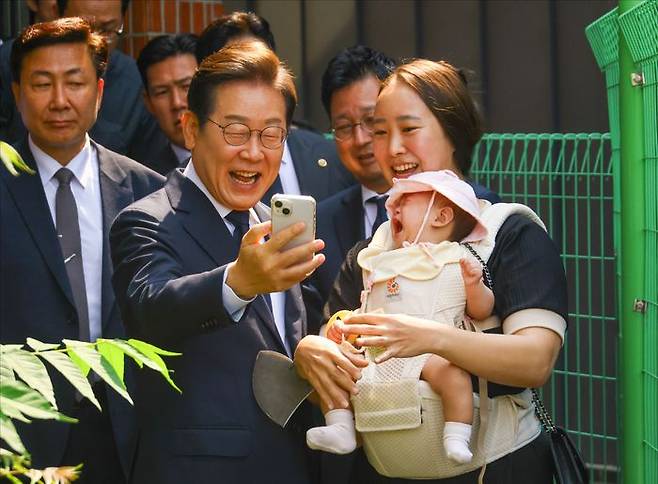 이재명 더불어민주당 후보가 29일 서울 서대문구 신촌동 주민센터 투표소에서 21대 대선 사전투표 참여 전 한 유권자와 기념사진을 촬영하고 있다. ⓒ데일리안 홍금표 기자