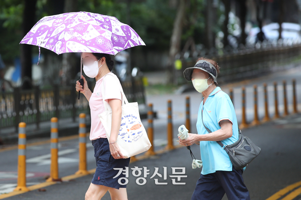 코로나19가 올해 여름에도 유행할 가능성이 높다는 전망이 나온다. 지난해 여름 코로나19 유행 시기에 폭염에도 불구하고 마스크를 쓴 시민들이 걸어가고 있는 모습이다. 정효진 기자