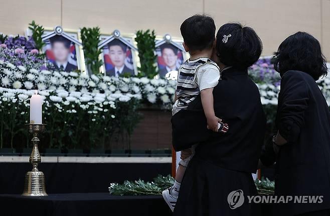 순직 해군 배웅하는 어린 아들 (포항=연합뉴스) 윤관식 기자 = 30일 경북 포항시 남구 해군 항공사령부 체육관에 마련된 '해군 P-3CK 917호기 순직자 합동분향소'에서 순직 해군의 유족과 어린 아들이 헌화하고 있다. 2025.5.30 psik@yna.co.kr