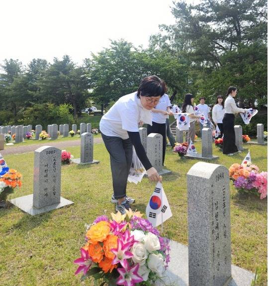 백춘희 대전문화재단 대표가 지난 30일 호국보훈의 달을 기념해 국립대전현충원 한 묘역에서 태극기를 꽂고 있다. 대전문화재단 제공