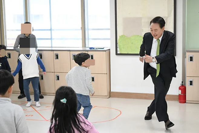 윤석열 대통령이 지난해 3월21일 강원도의 한 초등학교의 늘봄학교 ‘초1 맞춤형 프로그램’에 참여해 어린이들과 술래잡기 놀이를 함께하고 있다. 연합뉴스
